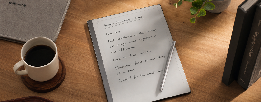 reMarkable tablet on a warm wooden desk displaying handwritten journal entries, with a stylus, coffee cup, books and plant in soft natural sunlight.