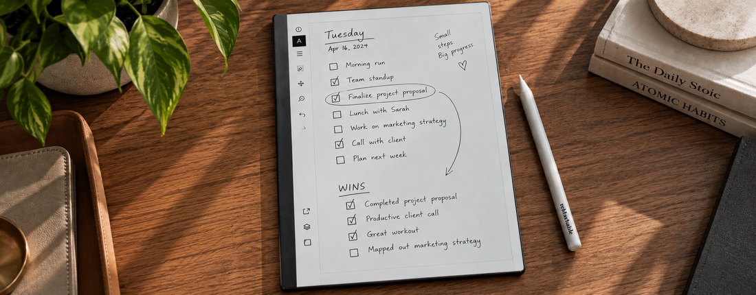 eMarkable tablet in portrait orientation on a wooden desk, displaying handwritten daily tasks and a Wins page using the Capture Tool.